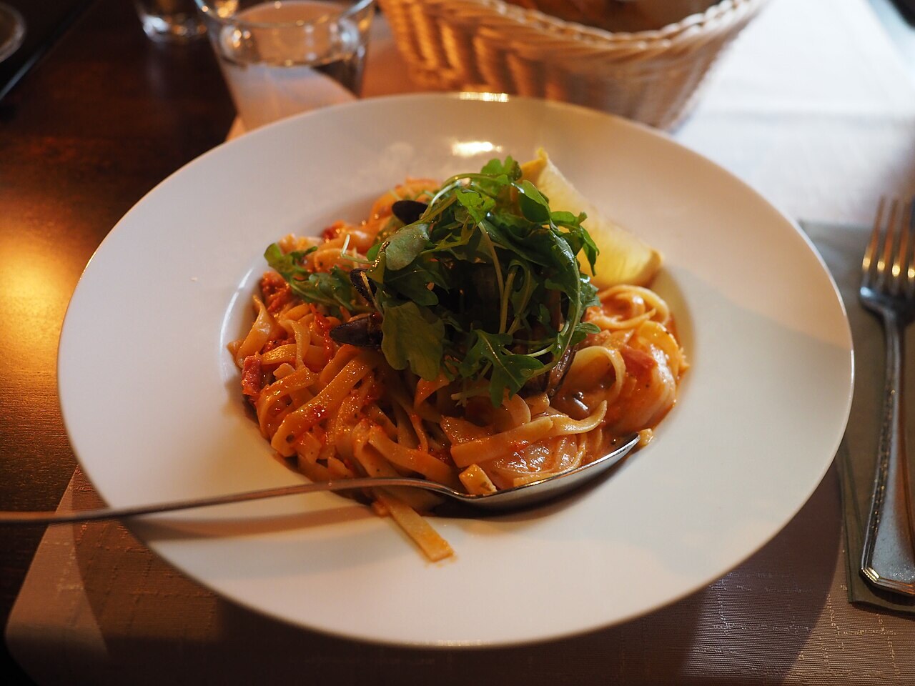 Fish pasta in creamy garlic sauce — Market fish and pasta in a silky garlic cream sauce, prepared with fresh herbs and seasonal produce.