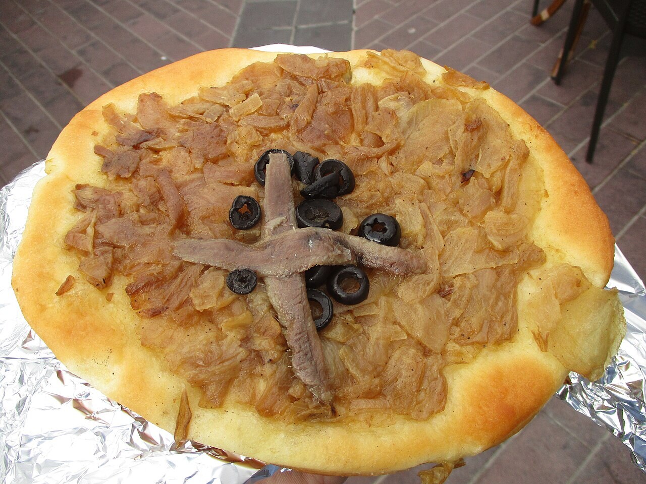 Pissaladière and apéro snacks — A classic Niçois onion tart with anchovies and olives, served with a changing selection of local apéritif bites.